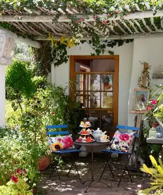 Patio con jardín mediterráneo con pérgola y zona de estar.