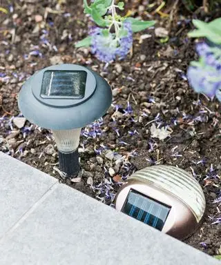 Eine Nahaufnahme von in den Boden eingelassenen Solarleuchten mit Ladeplatten oben