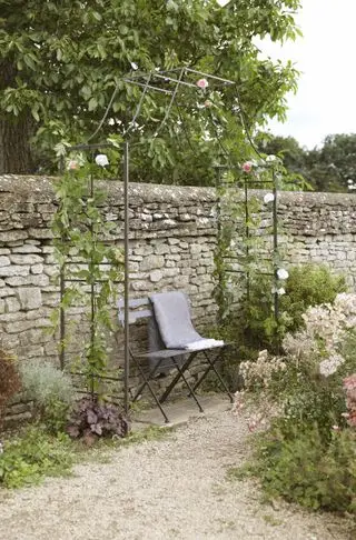 Gartenbank unter Rosenbogen im Bauerngarten
