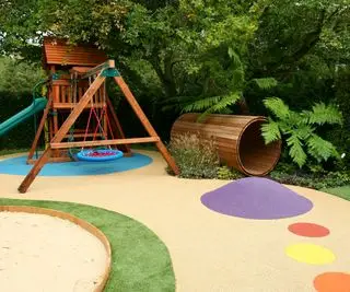 aire de jeux dans la cour arrière avec toboggan, portique et tube en bois
