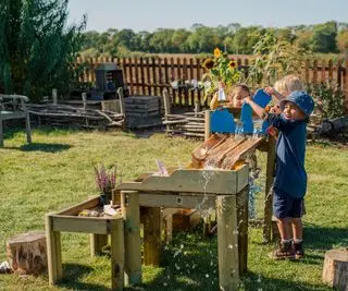 enfants jouant sur une nappe phréatique en bois dans une cour