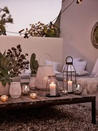 Malý zahradní balkon ve večerních hodinách s lucernami