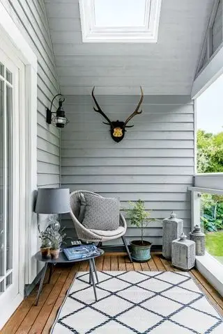 Malý balkon s židlí, nástěnným osvětlením a kobercem
