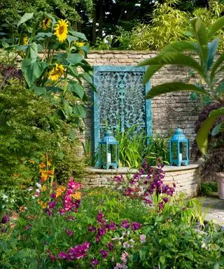 Muro de agua de bronce de filigrana de David Harber en un jardín campestre