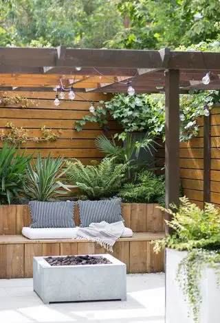 Recinzione da giardino e pergolato utilizzati per creare un'area salotto esterna integrata