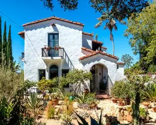 Casa blanca de estilo colonial español con techo rojo.