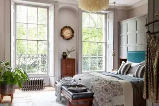Quarto em casa de época com venezianas de madeira