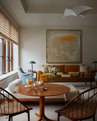 Sala de estar com persianas romanas e arte moderna na parede