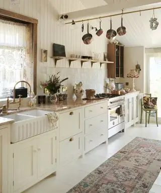 Et hvidt køkken med off-white shaker skabe, orange marmor bordplade og shiplap vægge