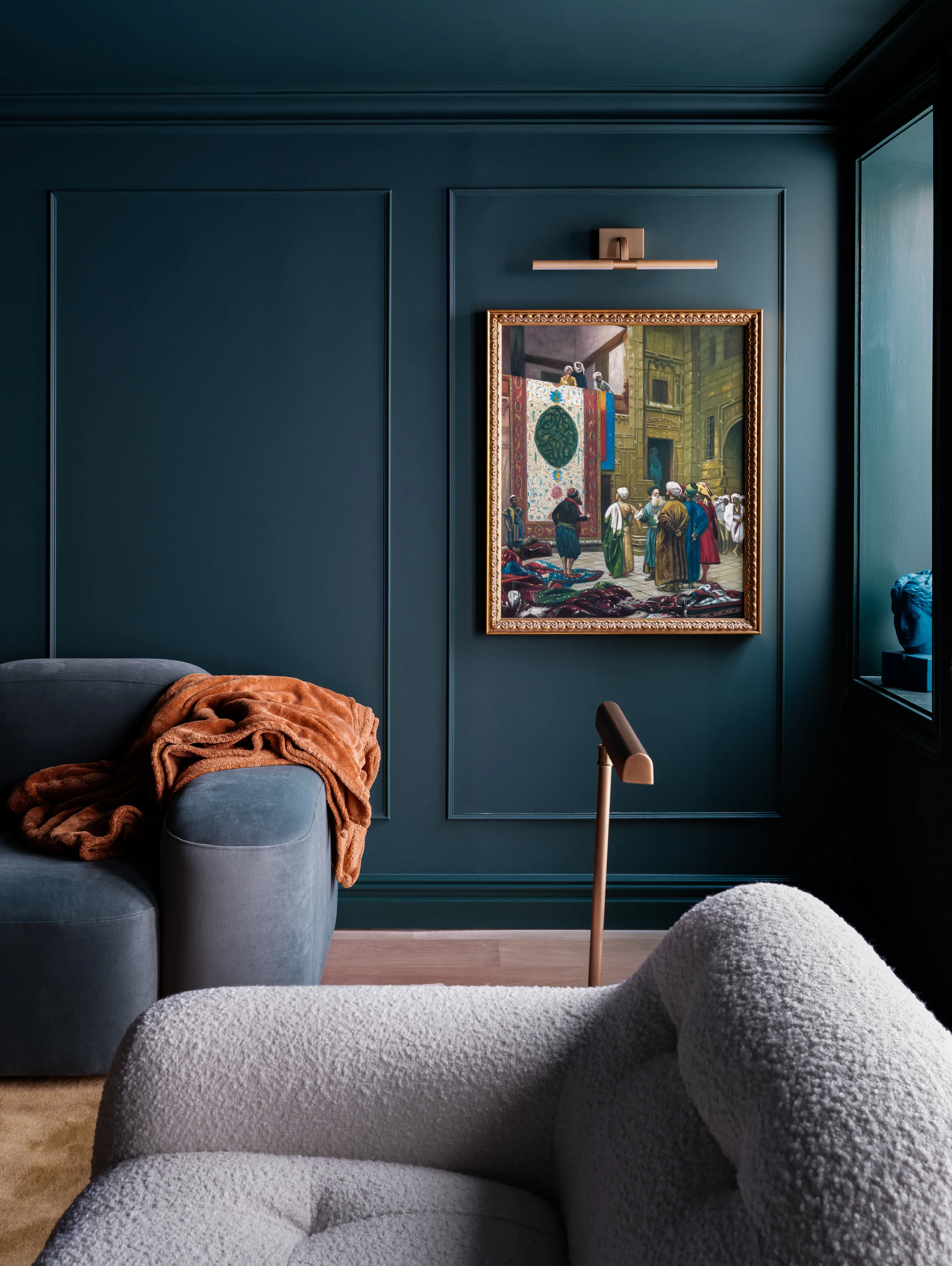 Marineblå stue med lavtliggende sofaer og vægkunst udstillet i en udsmykket ramme i antik stil' loading='lazy' title=