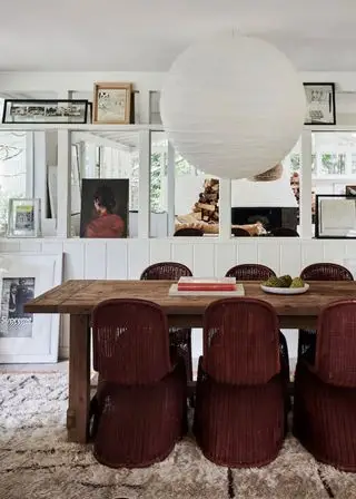 Gårdshusinnredningsideer, moderne spisestue med spisebord i tre, kurvstoler, kunstgallerivegg