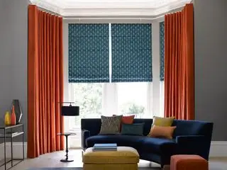 Una combinación de persianas y cortinas en un ventanal.