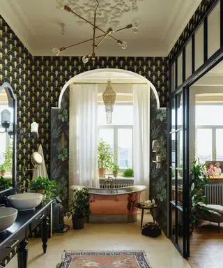 Une entrée art déco avec une porte cintrée et un papier peint vert foncé et or