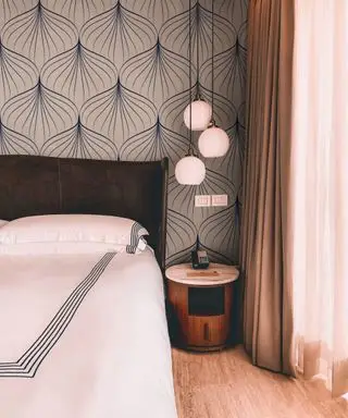 Une chambre rose avec des détails art déco, dont un luminaire sculptural