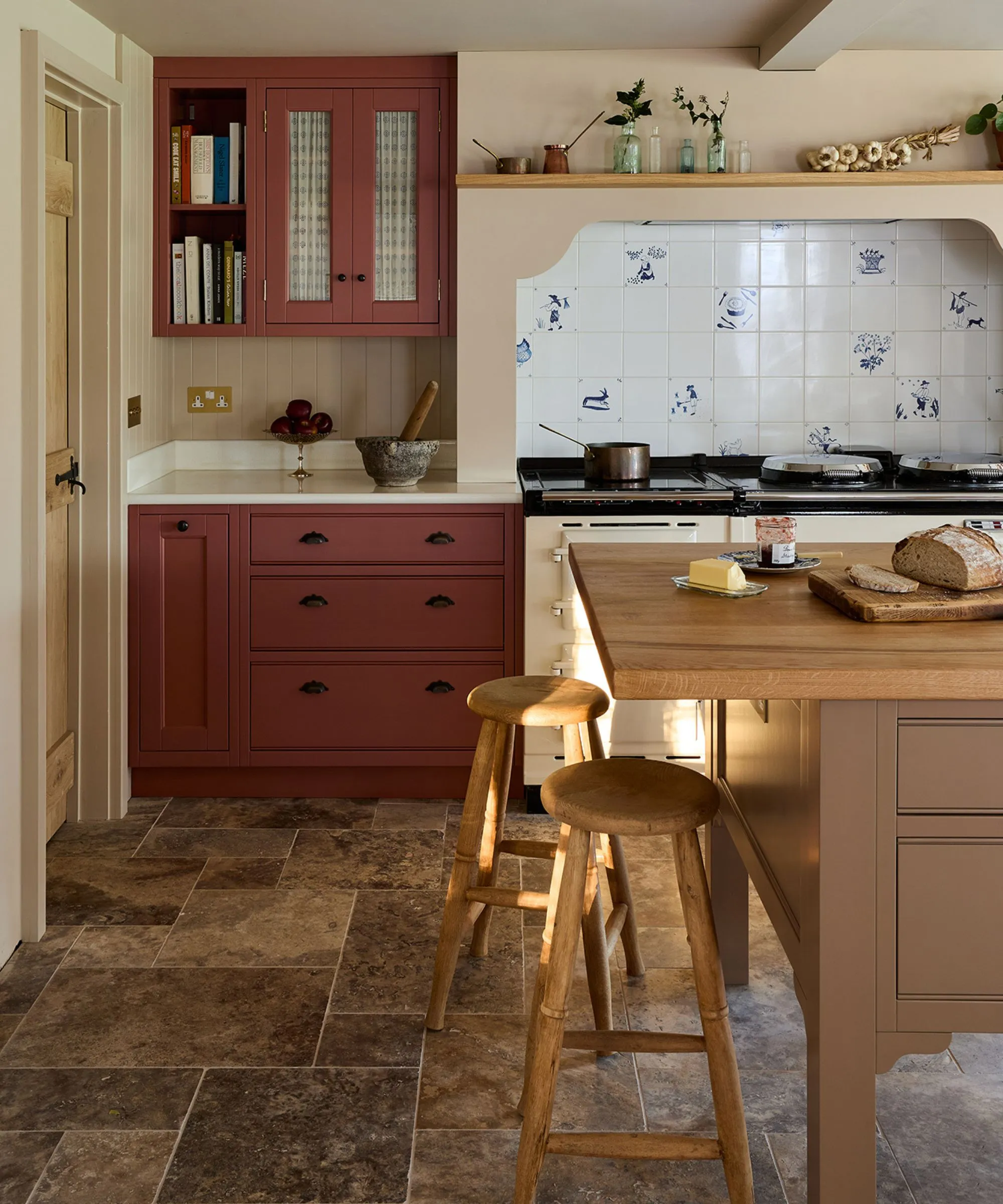 מטבח חווה כפרי עם סגנון וינטג' עם ארונות דו-גוני ורוד ובז', אי עץ גדול וכיריים ענקיות עם אריחי דלפט עבור ה-backsplash' loading='lazy' title=