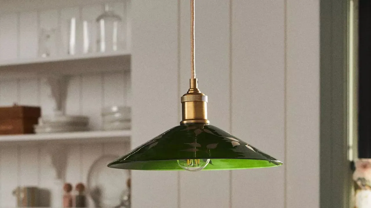 Anthropologie grønn glass pendellampe malt med botaniske motiver hengende inni en sjarmerende hvit frokostkrok' loading='lazy' title=