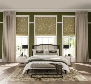 quarto com cama de casal e janelas decoradas com cortinas neutras e persianas com estampa verde