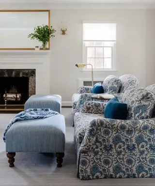 Soggiorno color crema con camino e divano con motivi blu