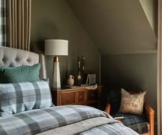 Piccola camera da letto verde oliva con soffitti inclinati e lenzuola a quadri