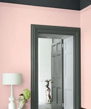 Angolo del soggiorno, pareti dipinte di rosa chiaro, finiture grigio scuro