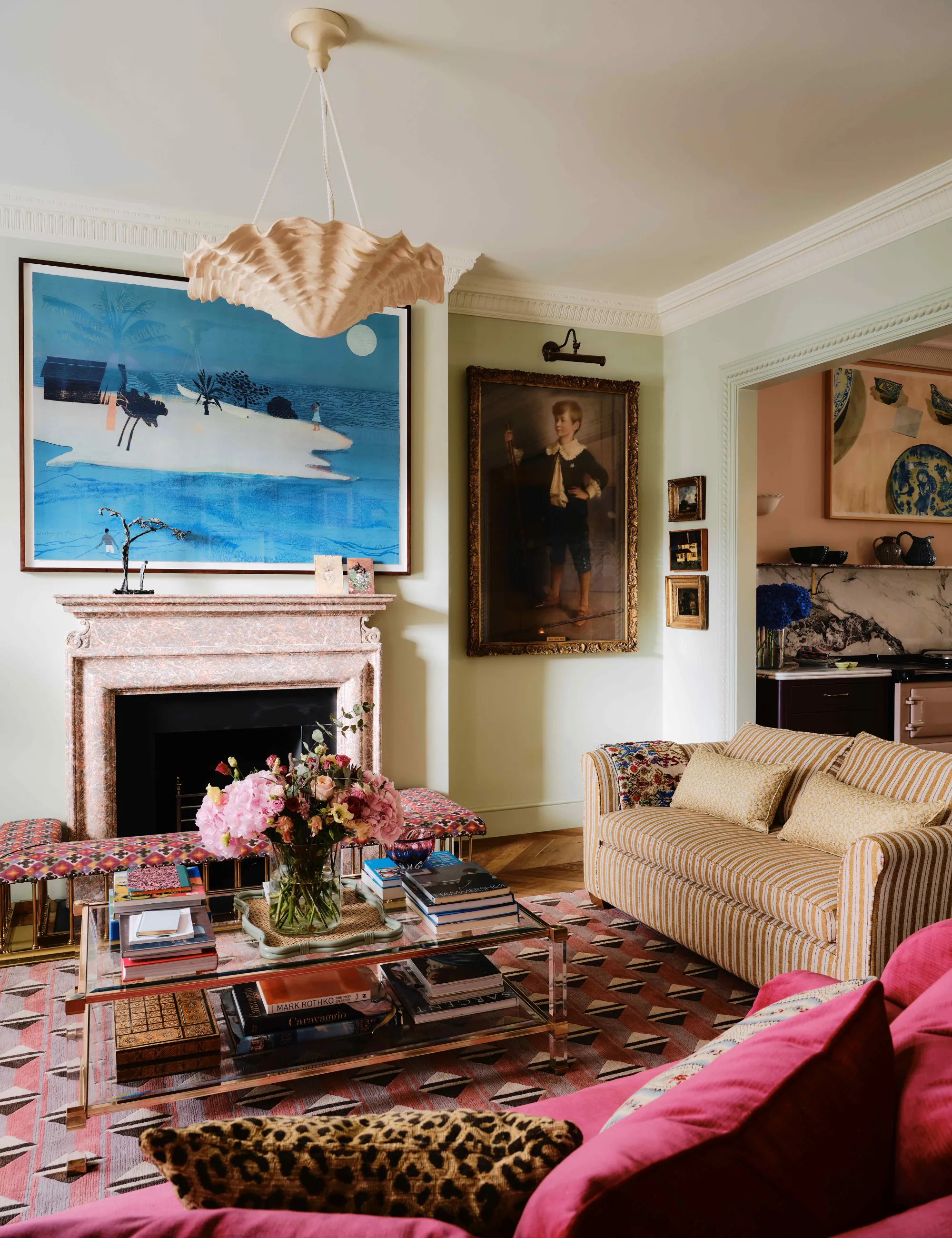 Warstwowy salon z geometrycznym, szklanym dywanikiem w kolorze fioletowo-purpurowym, dwupoziomowym stolikiem kawowym, sofą w paski i zebranymi grafikami ściennymi' loading='lazy' title=