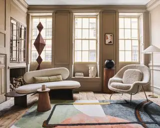 gran salón con paredes de color marrón claro, grandes ventanales y muebles modernos