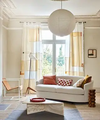 Sala de baño neutra con sofá color crema curvo