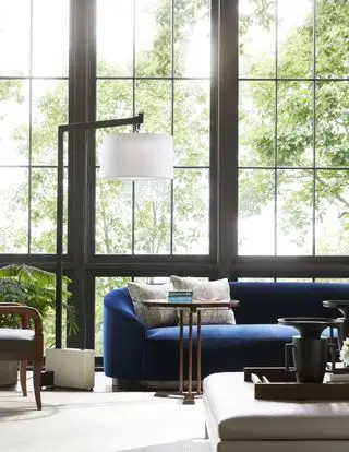stue med blå sofa, gulvlampe, sidebord, creme gulvtæppe