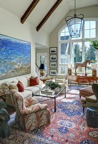 Salón abovedado de estilo francés con antigüedades y alfombra persa.