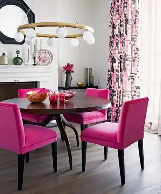 Sala de jantar pequena com cadeiras rosa brilhante