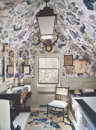 Cuarto de baño con papel tapiz floral morado y silla.