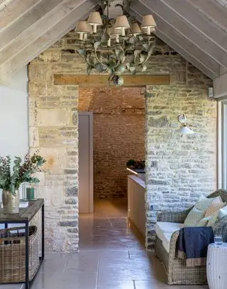 Rustikaler Flur mit Steinwand-Konsolentisch aus Holz und Metallkronleuchter