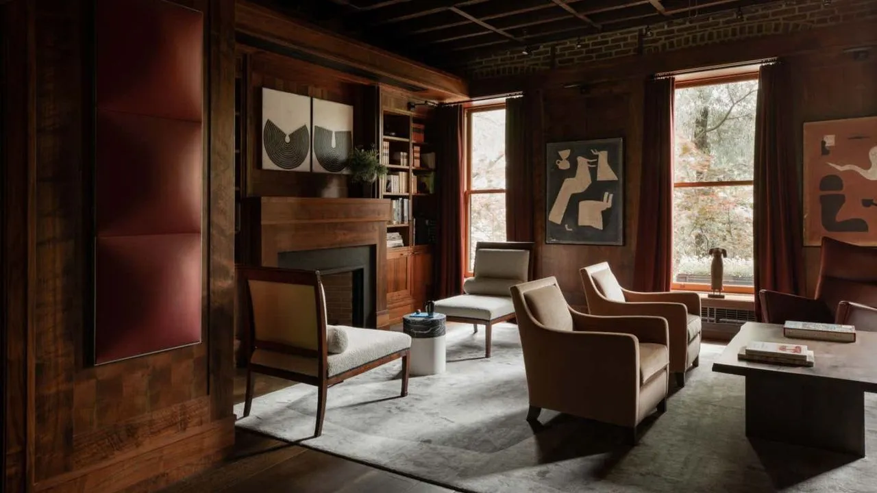 深紅に塗られたリビングルームには、独立したシーティングエリアが 2 つあります。 Wood panelling on the walls.' loading='lazy' title=