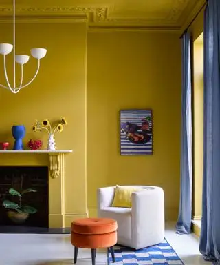 Sala de estar en Smokey Green de Benjamin Moore con detalle de molduras en Outrageous Orange