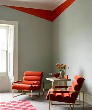 Sala de estar en Smokey Green de Benjamin Moore con detalle de molduras en Outrageous Orange