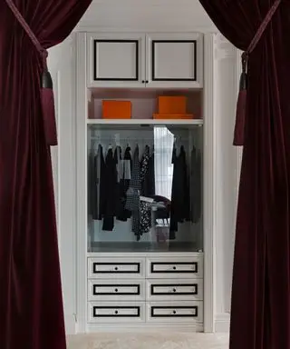 Pohled na procházku ve wardrove, orámovaný elegantními, sametově fialovými závěsy