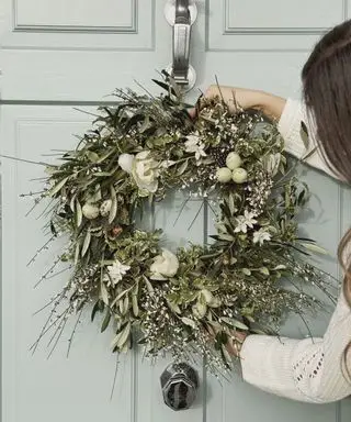 corona de puerta de pascua en una puerta verde pálida
