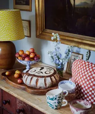 aparador lleno de decoración primaveral y pascual, como pan horneado temático, fruta fresca y flores