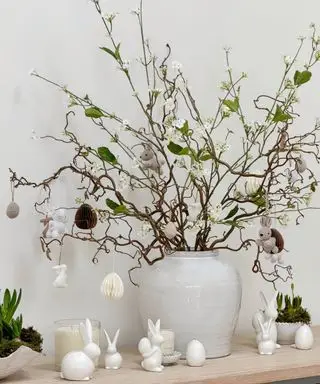 gran jarrón urna con ramitas decoradas con adornos de Pascua