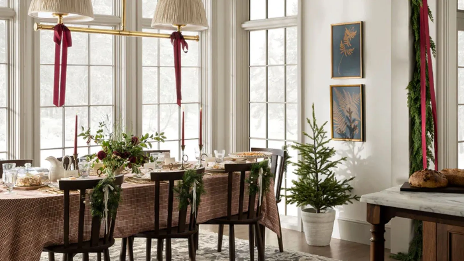Stor lys neutral spisestue med store vinduer dekoreret til jul med en løv Garland Røde bånd,' loading='lazy' title=