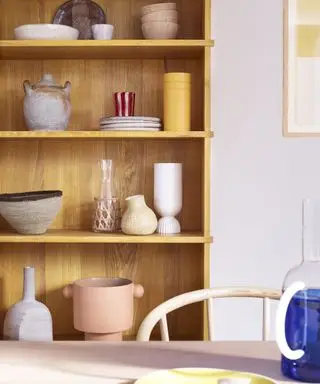 trehylle med utstilling av keramikk og servise