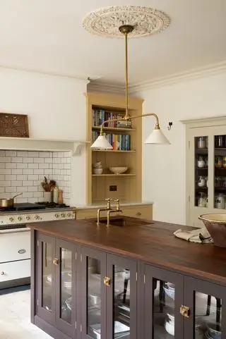 cocina amarilla de devol con paredes claras y una isla de cocina de madera oscura