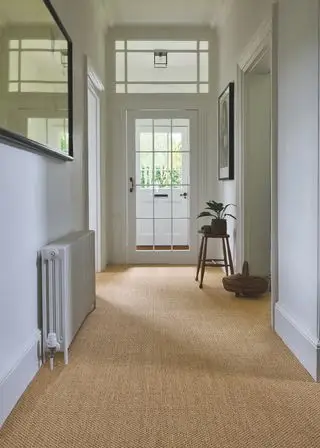 hvit entré med sisalgulv, krakk, plante, kunstverk
