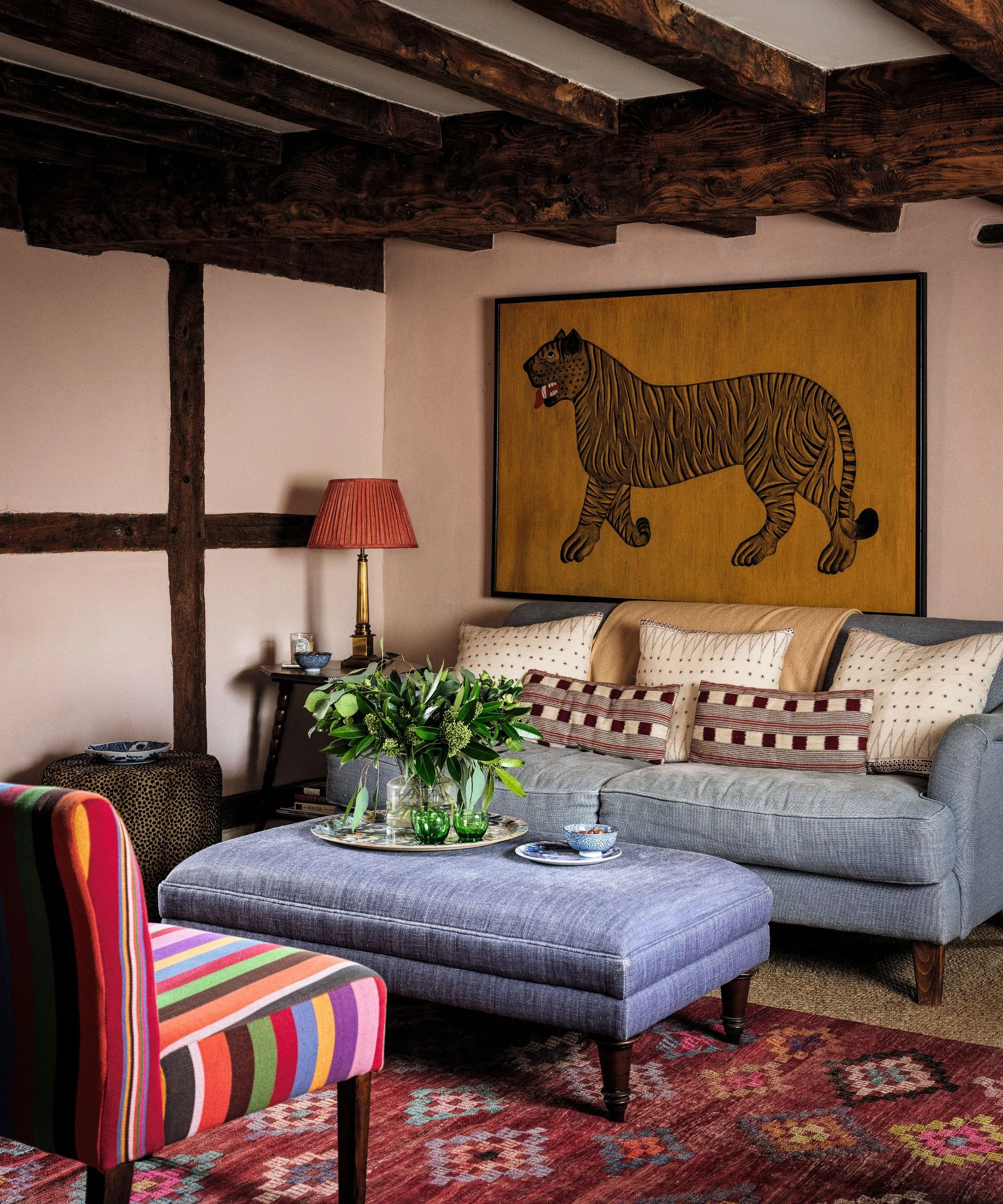 Entrada decorada para o Natal com área de estar em um canto composta por mesa circular de madeira e cadeiras de madeira' loading='lazy' title=