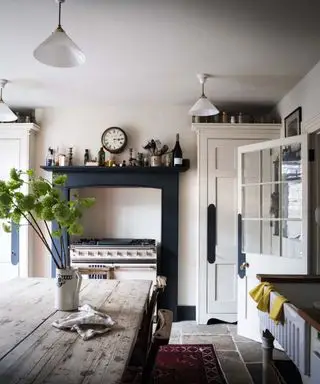 Cocina blanca con carpintería azul oscuro.