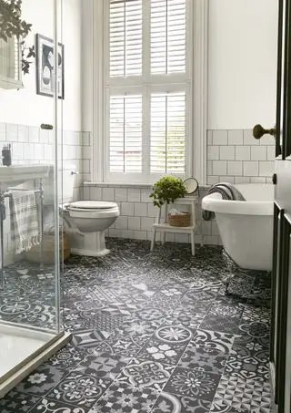 banheiro branco com banheira vitoriana, persianas, piso vinílico cinza, preto e branco