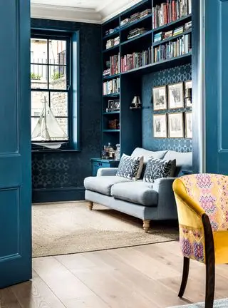 quarto confortável com esquema de cores azul e pequeno sofá no recanto