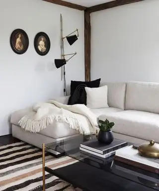 quarto confortável com parede caiada e sofá em forma de L