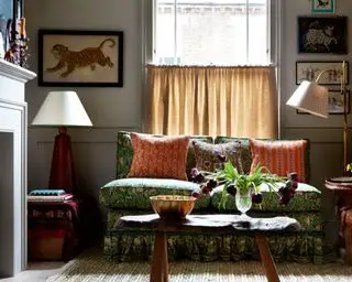 quarto confortável com pequeno sofá estampado e mesa de centro antiga