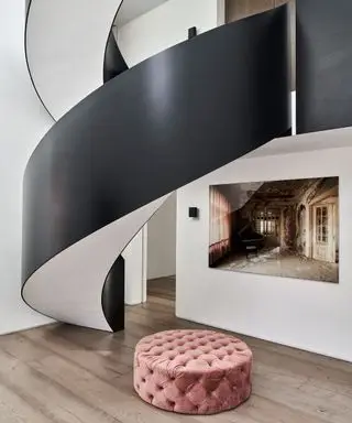 Moderner Eingangsbereich mit schwarz gestrichener Wendeltreppe